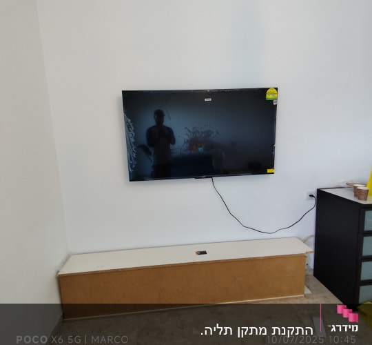 טלוויזיה מותקנת על קיר עם כבלים גלויים
